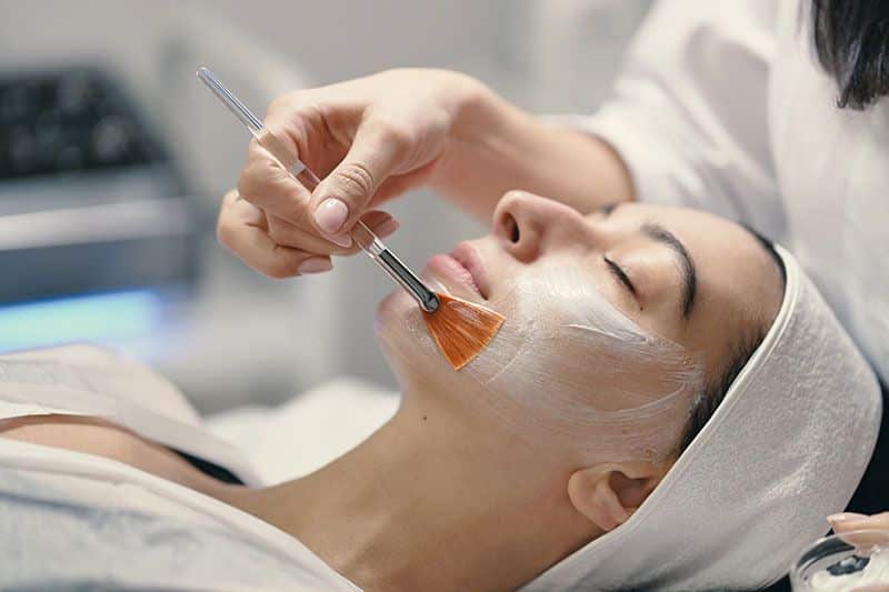 mujer realizando un tratamiento facial en un centro de estética