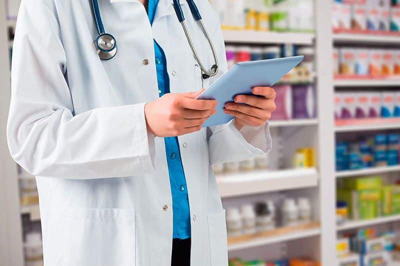 farmacéutico mira en su tablet información sobre seo en el sector farmacias